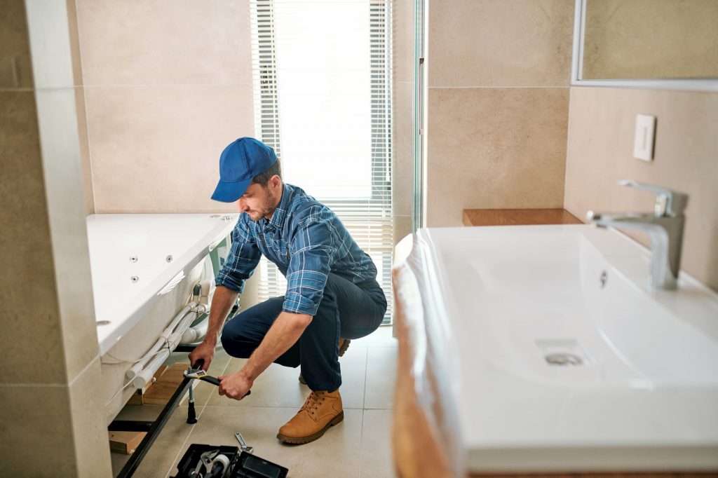 domon reno group plumber installing bathtub in new renovated bathroom - bathroom renovations toronto